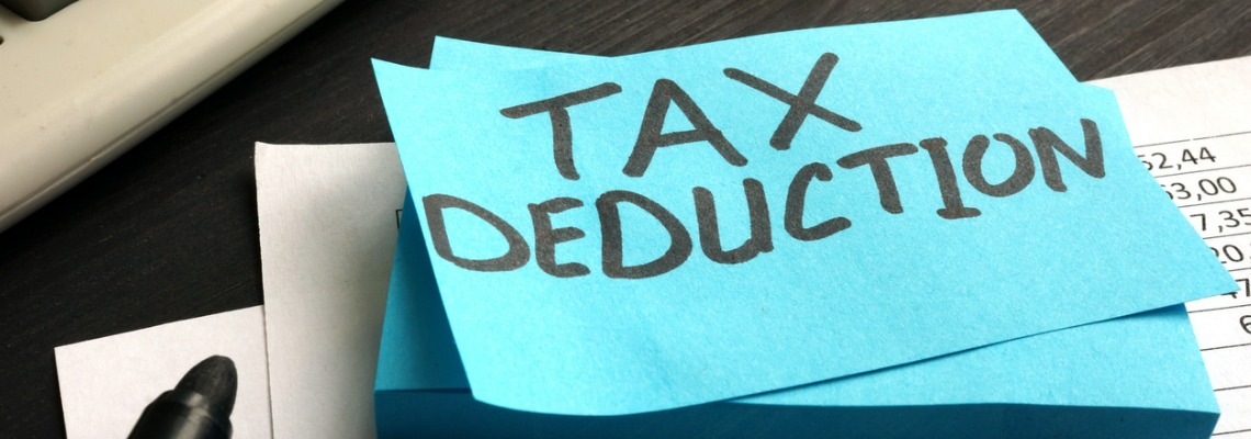 tax deduction written on a piece of blue paper.