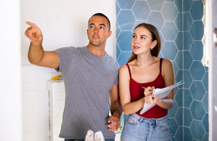 man and woman standing in bathroom planning
